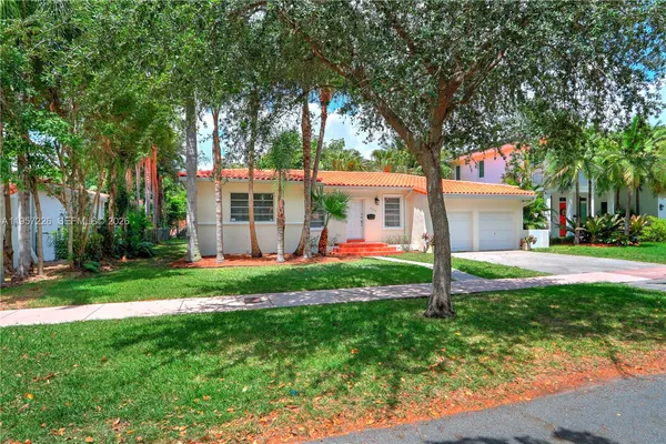 a view of a house with backyard and a tree