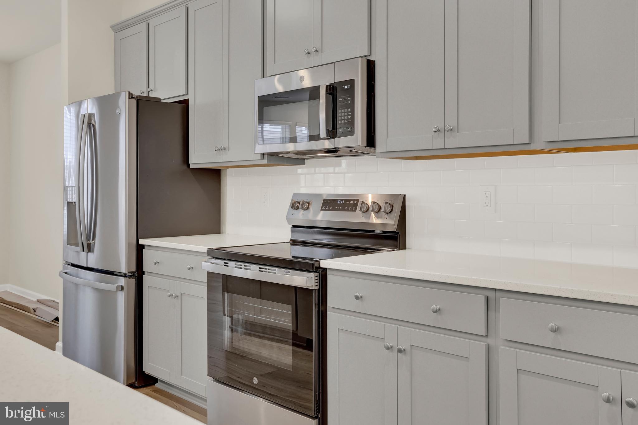 9666 Swallowtail Lane Manassas, VA 20110 - Photo 14 of 92 a kitchen with stainless steel appliances granite countertop white cabinets a refrigerator and a stove
