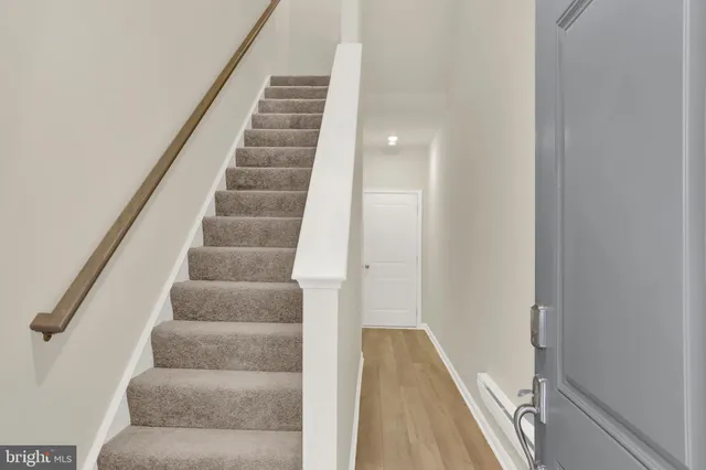 a view of an empty room with wooden floor and windows
