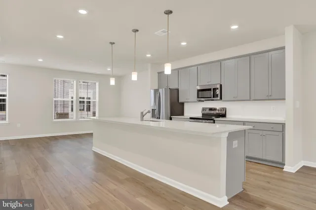 a kitchen with kitchen island a sink stainless steel appliances and cabinets