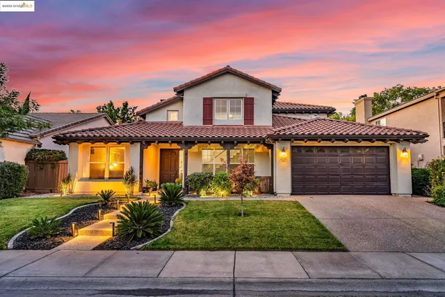 a front view of a house with a yard and potted plants
