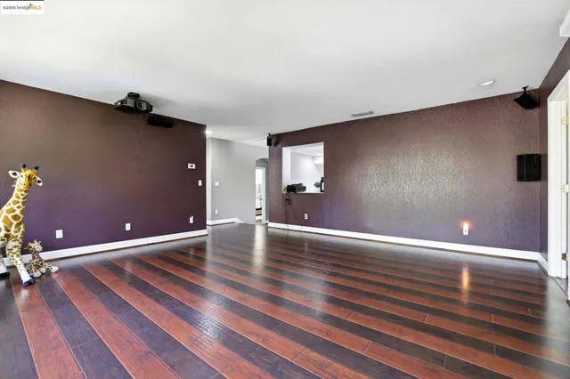 a view of room with wooden floor and floor to ceiling window