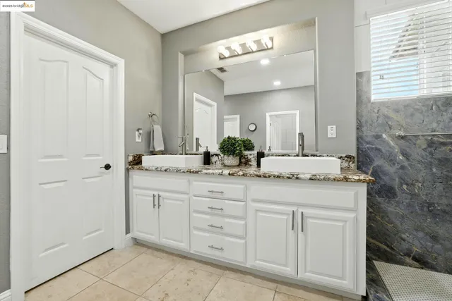 a bathroom with a sink shower and a mirror