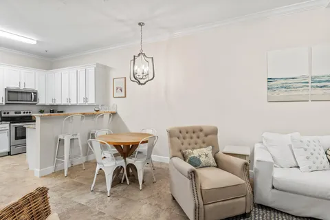 a living room with furniture kitchen and a chandelier