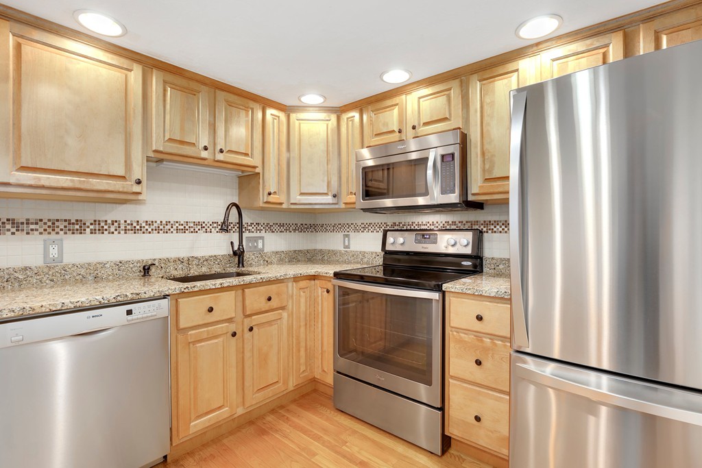 5 Porter Road, Unit A2 Andover, MA 01810 - Photo 15 of 22 a kitchen with granite countertop a refrigerator stove top oven and sink