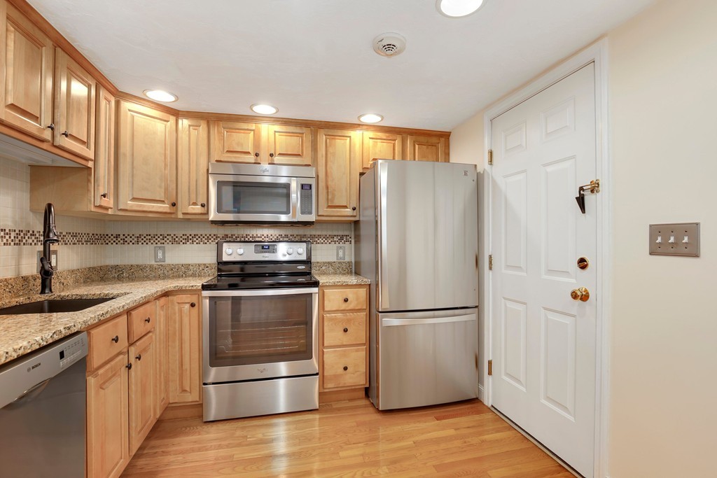 5 Porter Road, Unit A2 Andover, MA 01810 - Photo 16 of 22 a kitchen with granite countertop a refrigerator stove and microwave