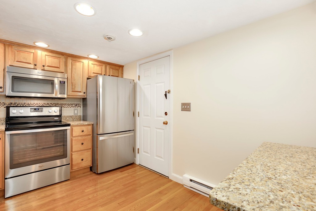 5 Porter Road, Unit A2 Andover, MA 01810 - Photo 17 of 22 a kitchen with a refrigerator stove and wooden floor