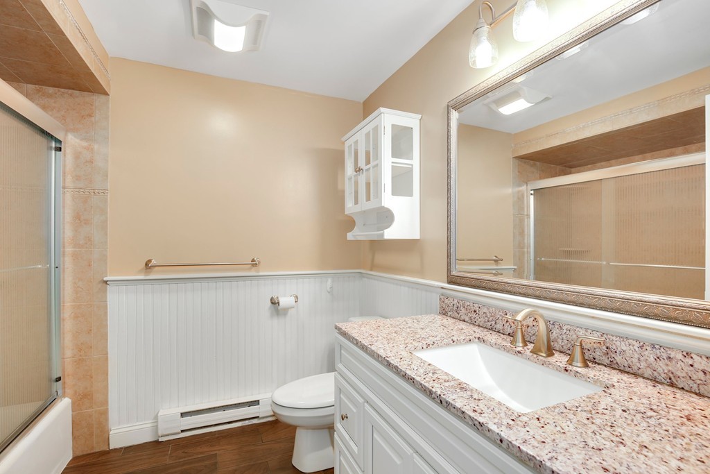 5 Porter Road, Unit A2 Andover, MA 01810 - Photo 9 of 22 a bathroom with a granite countertop sink and a mirror