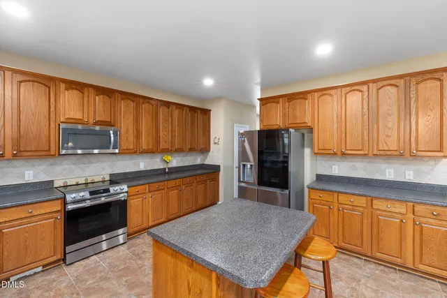 a kitchen with stainless steel appliances granite countertop a refrigerator a stove top oven a sink and dishwasher