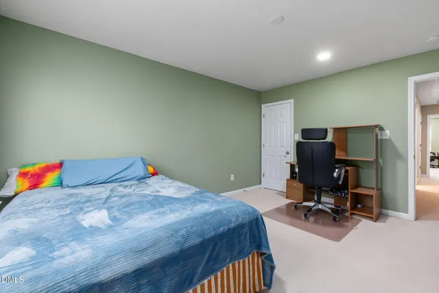 a bedroom with a bed and a chair in it