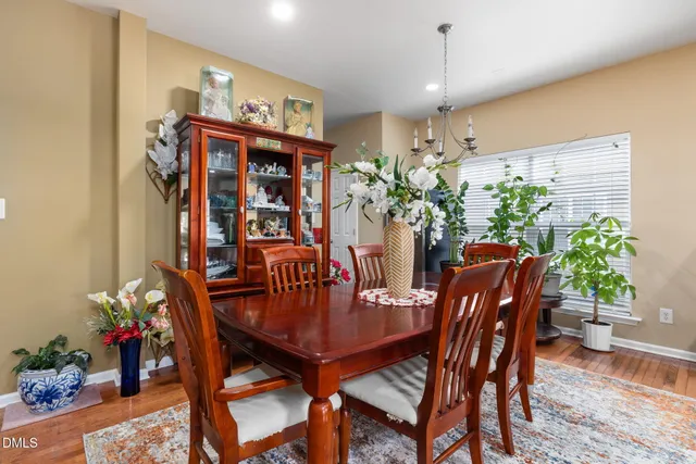 a dining room with furniture potted plants and wooden floor