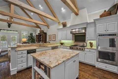 a kitchen with granite countertop a sink and cabinets