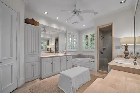 a spacious bathroom with a double vanity sink a mirror a bathtub and a shower