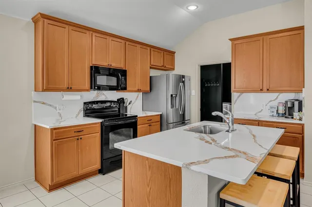 a kitchen with stainless steel appliances granite countertop a refrigerator stove microwave and sink