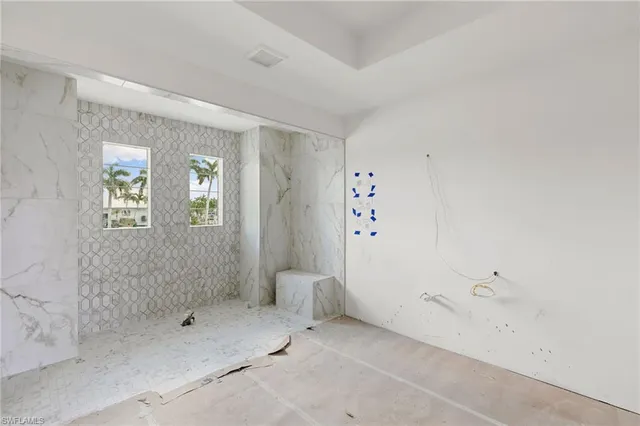 a spacious bathroom with a granite countertop sink mirror and a bathtub