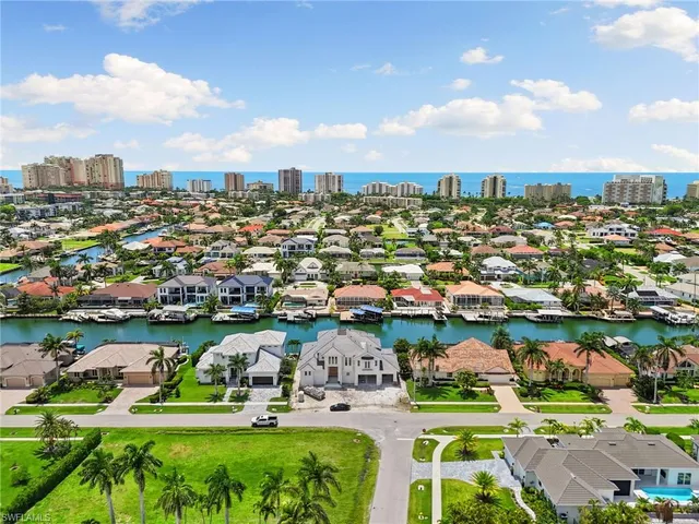 an aerial view of a house with a lake view and large trees