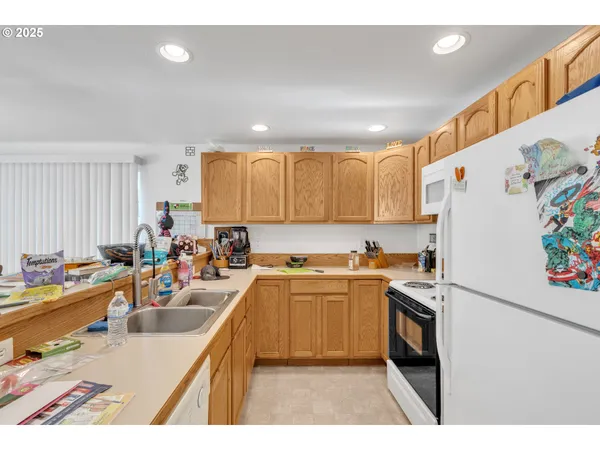 a kitchen that has a lot of cabinets a sink and appliances in it