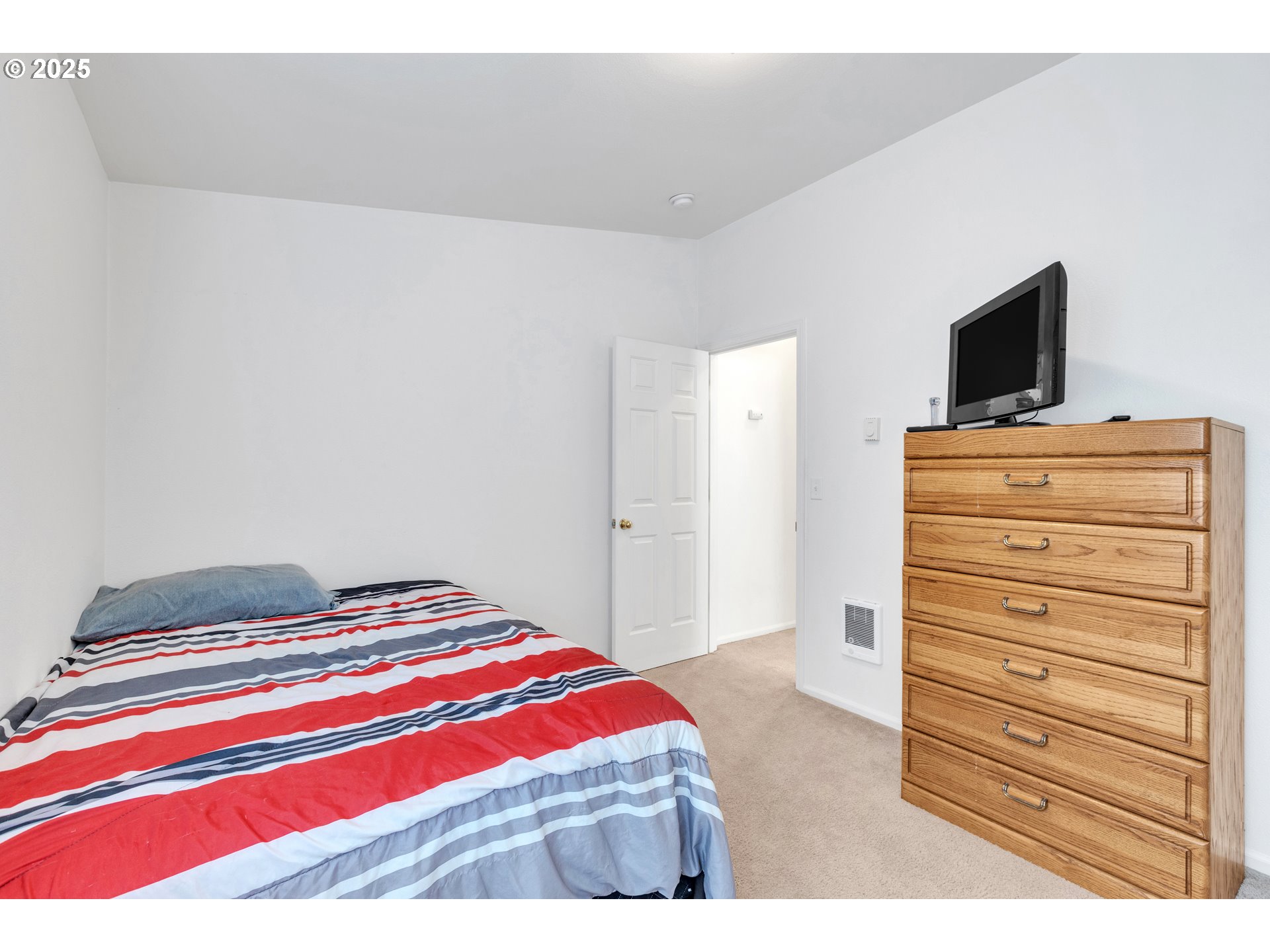 3397 Oak Street Florence, OR 97439 - Photo 19 of 48 a bedroom with a bed and a flat screen tv