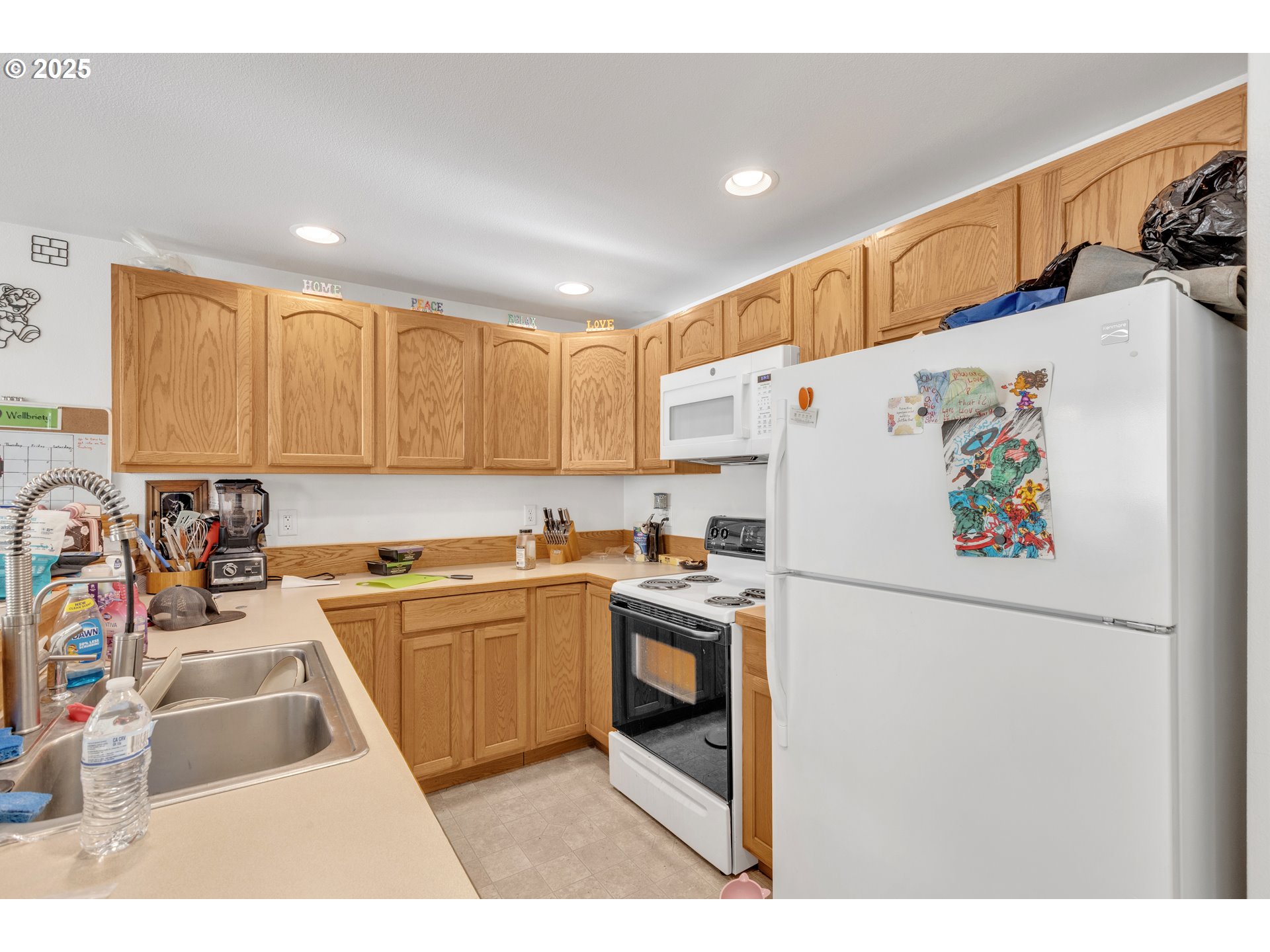 3397 Oak Street Florence, OR 97439 - Photo 10 of 48 a kitchen with a refrigerator a stove a sink dishwasher and a microwave with wooden floor