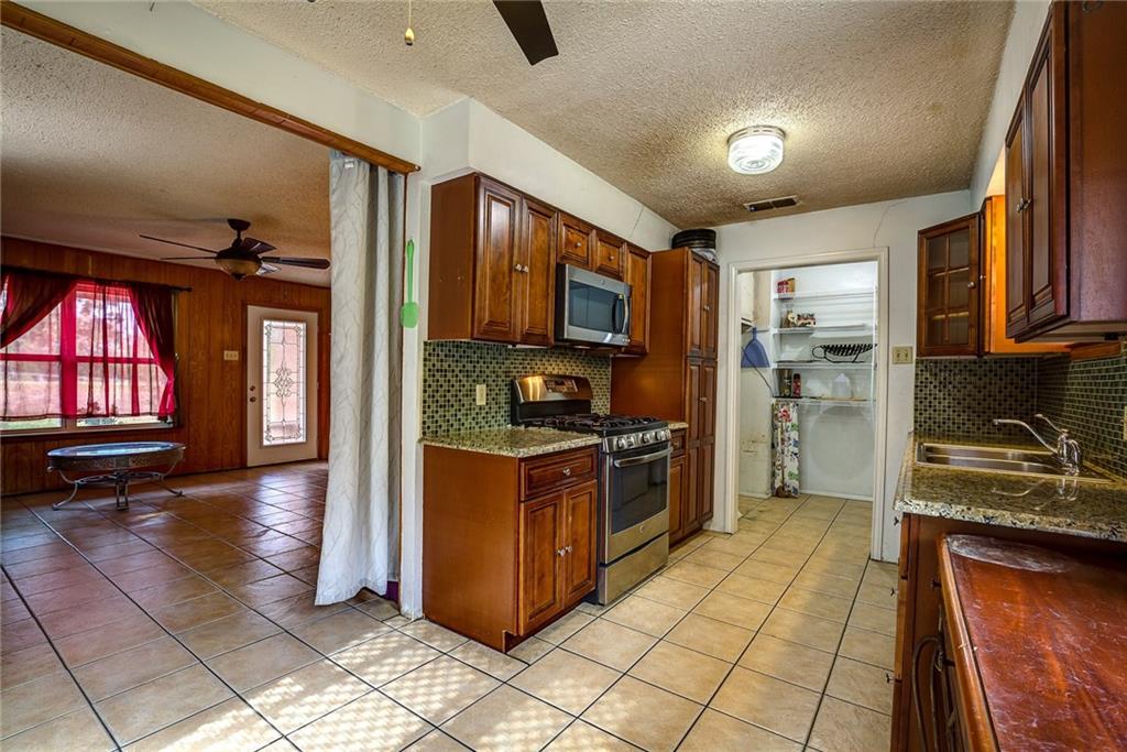 5627 Horizon Road Rockwall, TX 75032 - Photo 17 of 23 a kitchen with stainless steel appliances granite countertop a refrigerator a stove top oven and a sink