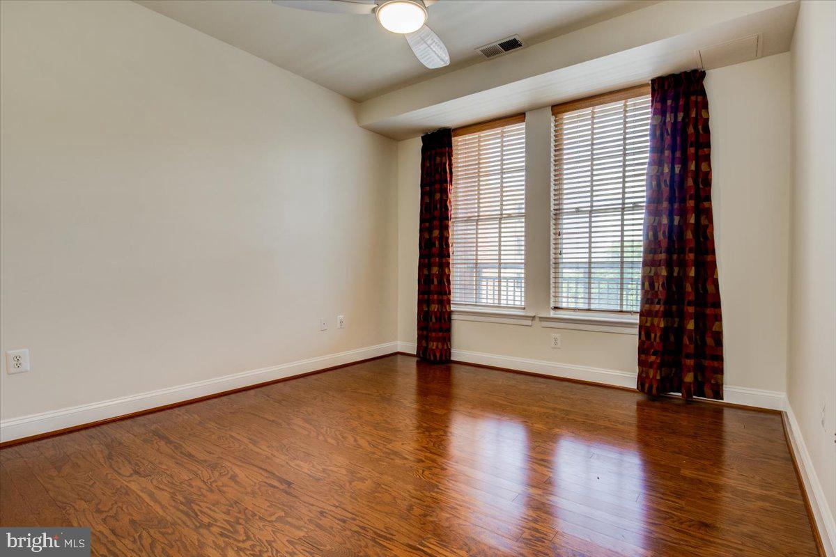 1023 North Royal Street, Unit 208 Alexandria, VA 22314 - Photo 13 of 29 a view of an empty room with wooden floor and a window