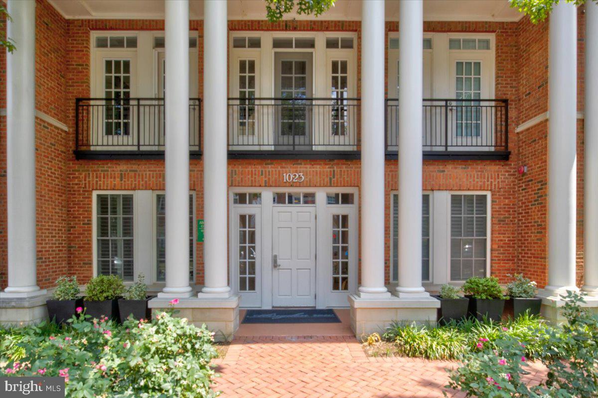 1023 North Royal Street, Unit 208 Alexandria, VA 22314 - Photo 2 of 29 front view of a brick house with a large windows and potted plants
