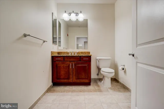 a spacious bathroom with a toilet a sink and mirror
