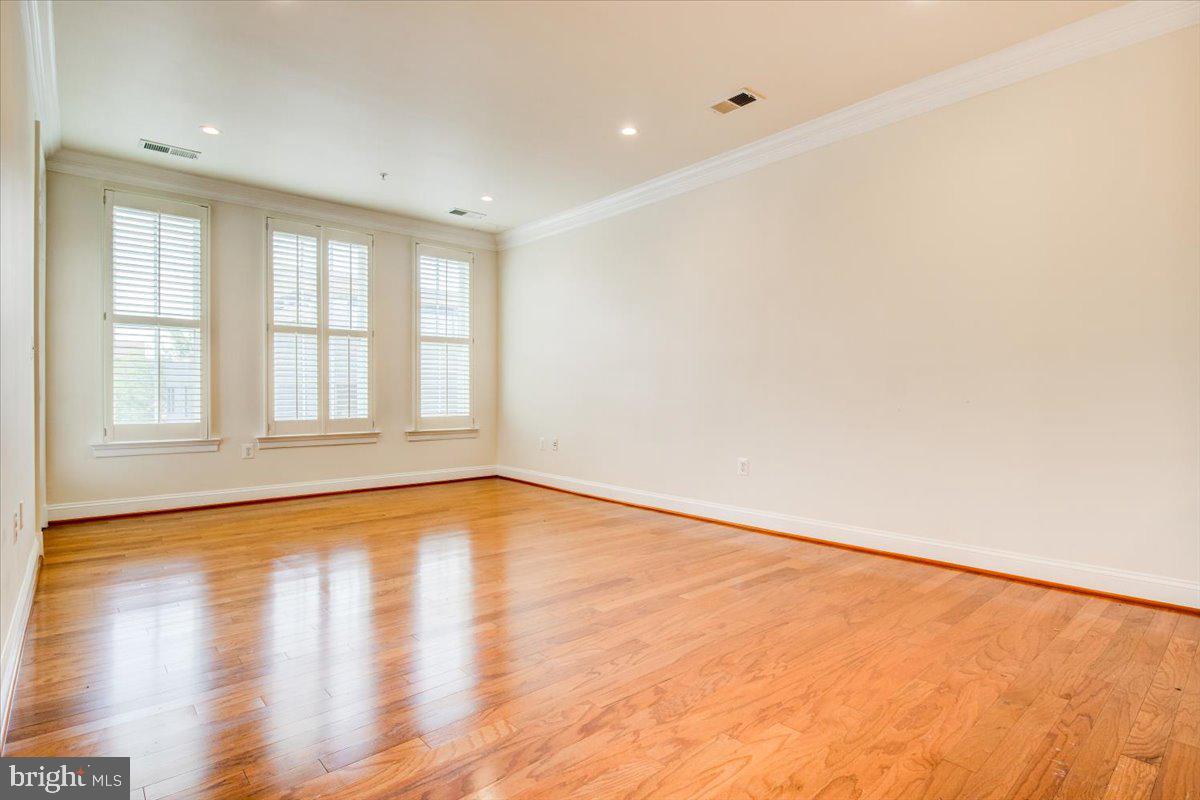 1023 North Royal Street, Unit 208 Alexandria, VA 22314 - Photo 6 of 29 a view of an empty room with wooden floor and a window