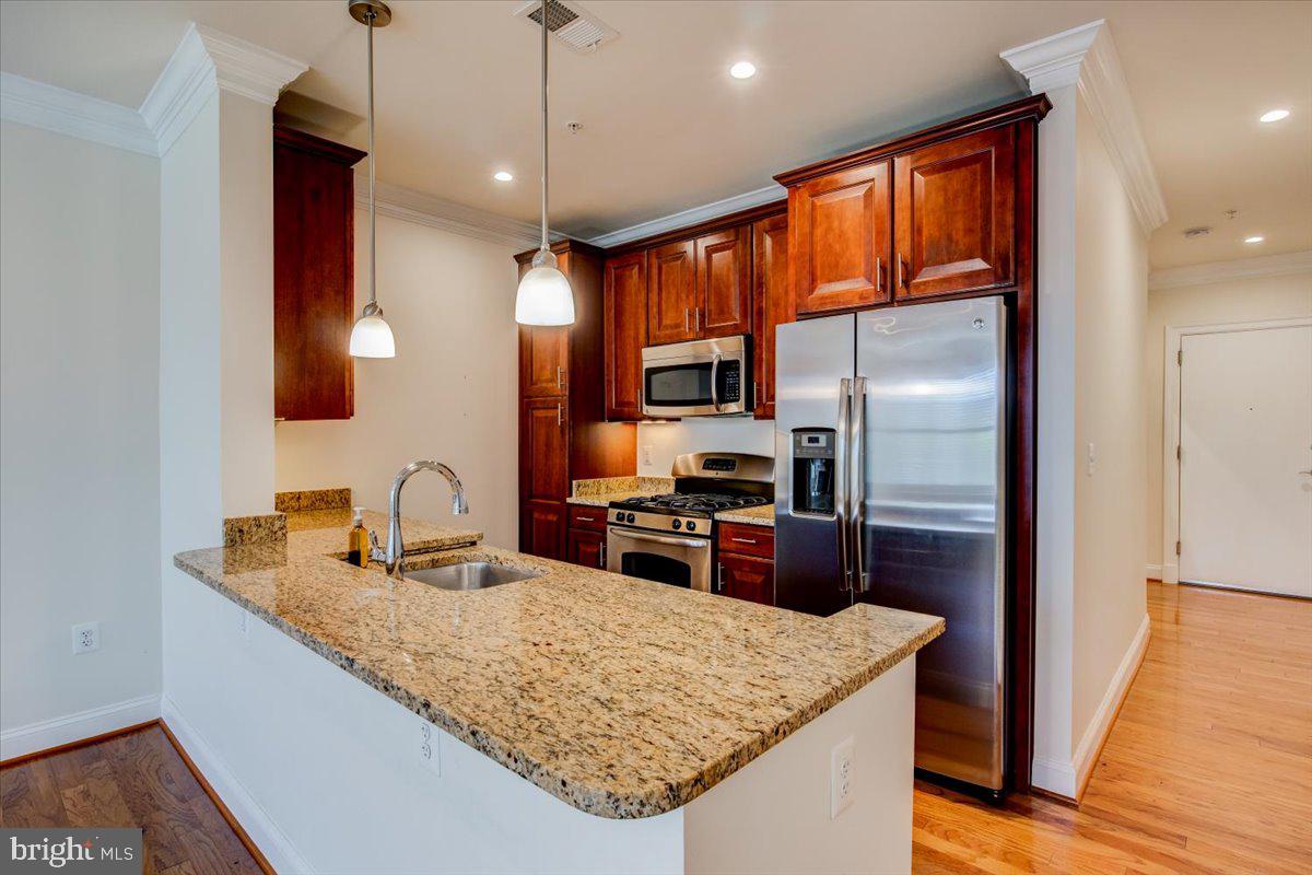 1023 North Royal Street, Unit 208 Alexandria, VA 22314 - Photo 7 of 29 a kitchen with stainless steel appliances granite countertop a sink refrigerator and microwave