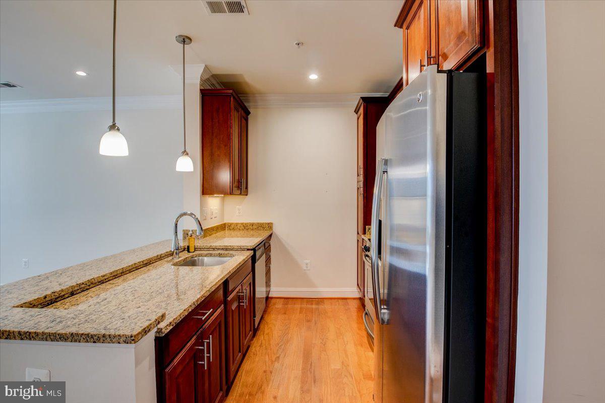 1023 North Royal Street, Unit 208 Alexandria, VA 22314 - Photo 8 of 29 a kitchen with a sink and a refrigerator