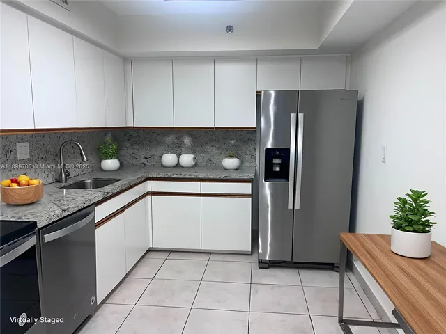 a kitchen with stainless steel appliances granite countertop a refrigerator and a sink