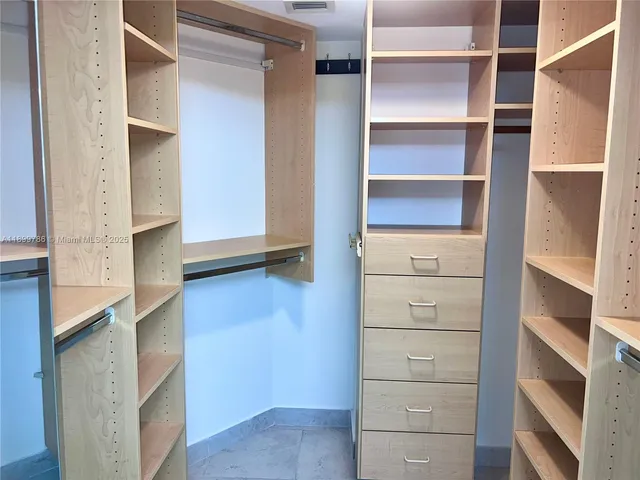 a view of walk in closet with empty racks