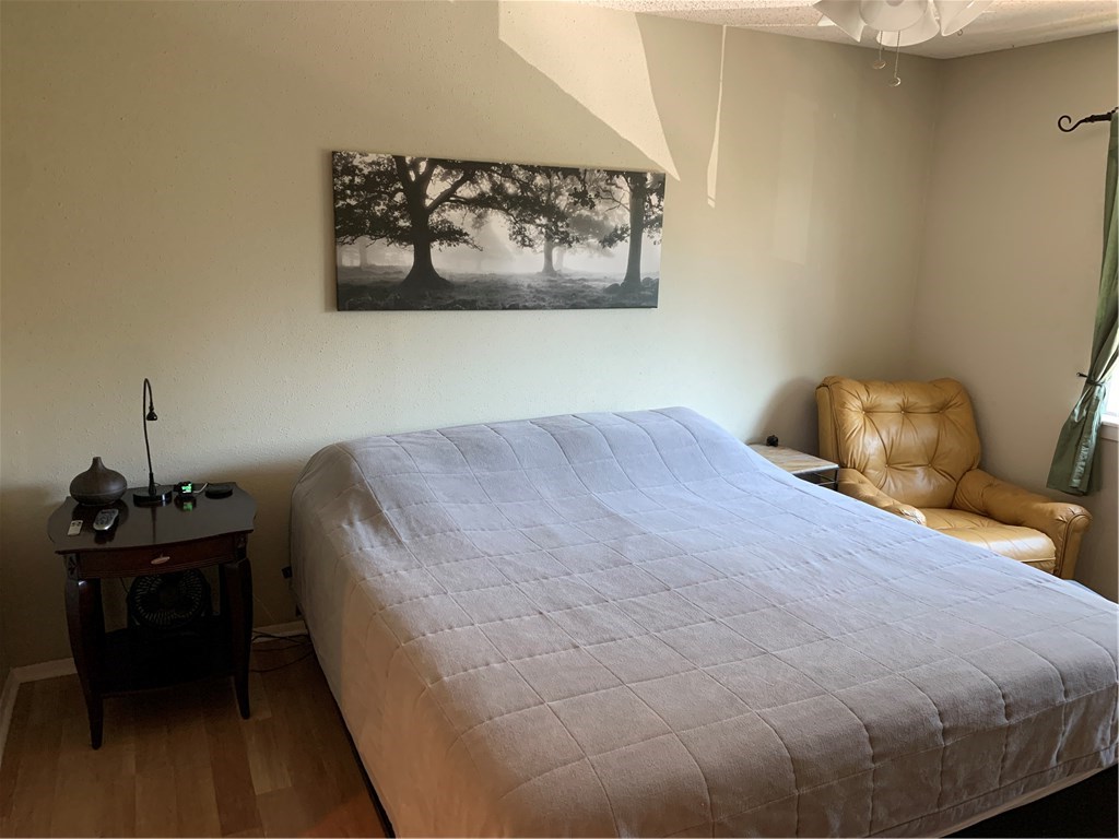 8210 Bent Tree Road, Unit 226 Austin, TX 78759 - Photo 13 of 15 a bedroom with a bed and wooden floor