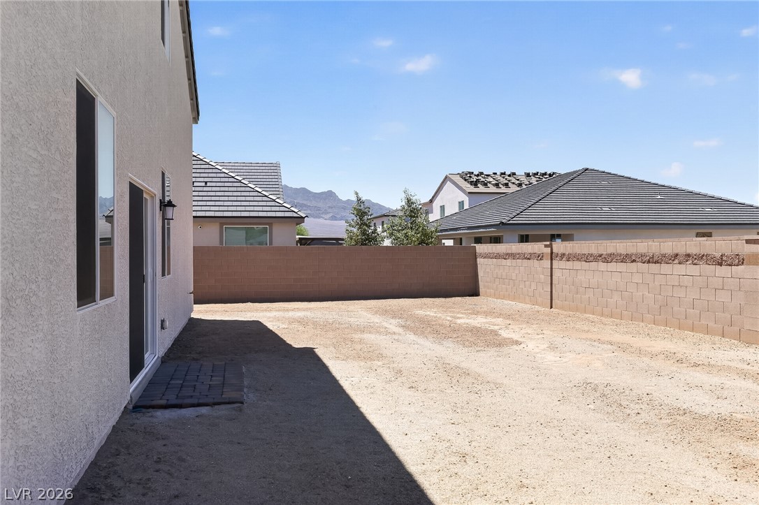 347 Sam Way Mesquite, NV 89027 - Photo 3 of 32 A spacious backyard awaits personalization, bordered by sturdy block fencing under an expansive blue sky.