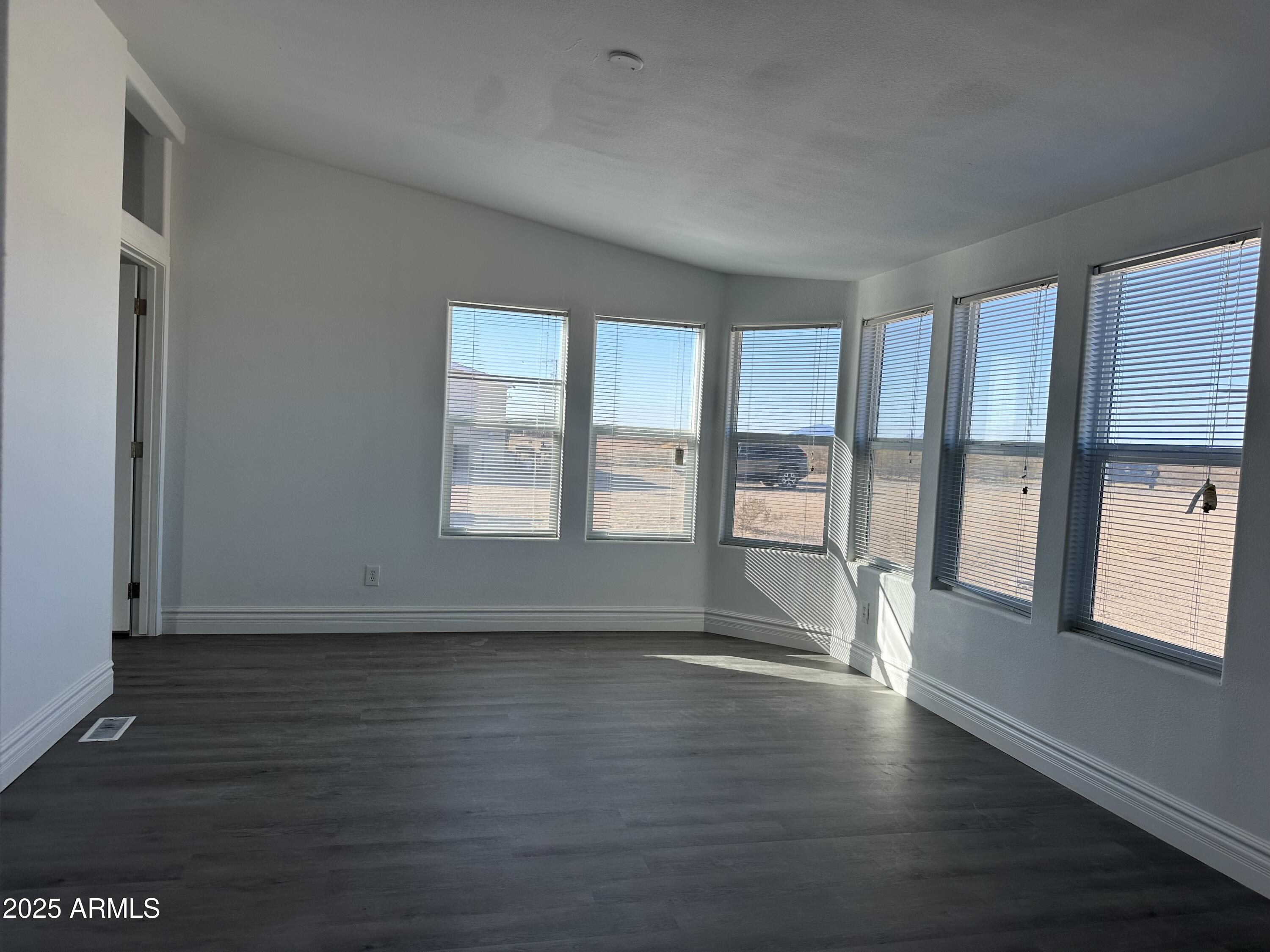 38007 West McDowell Road Tonopah, AZ 85354 - Photo 2 of 44 a view of an empty room with a window and wooden floor