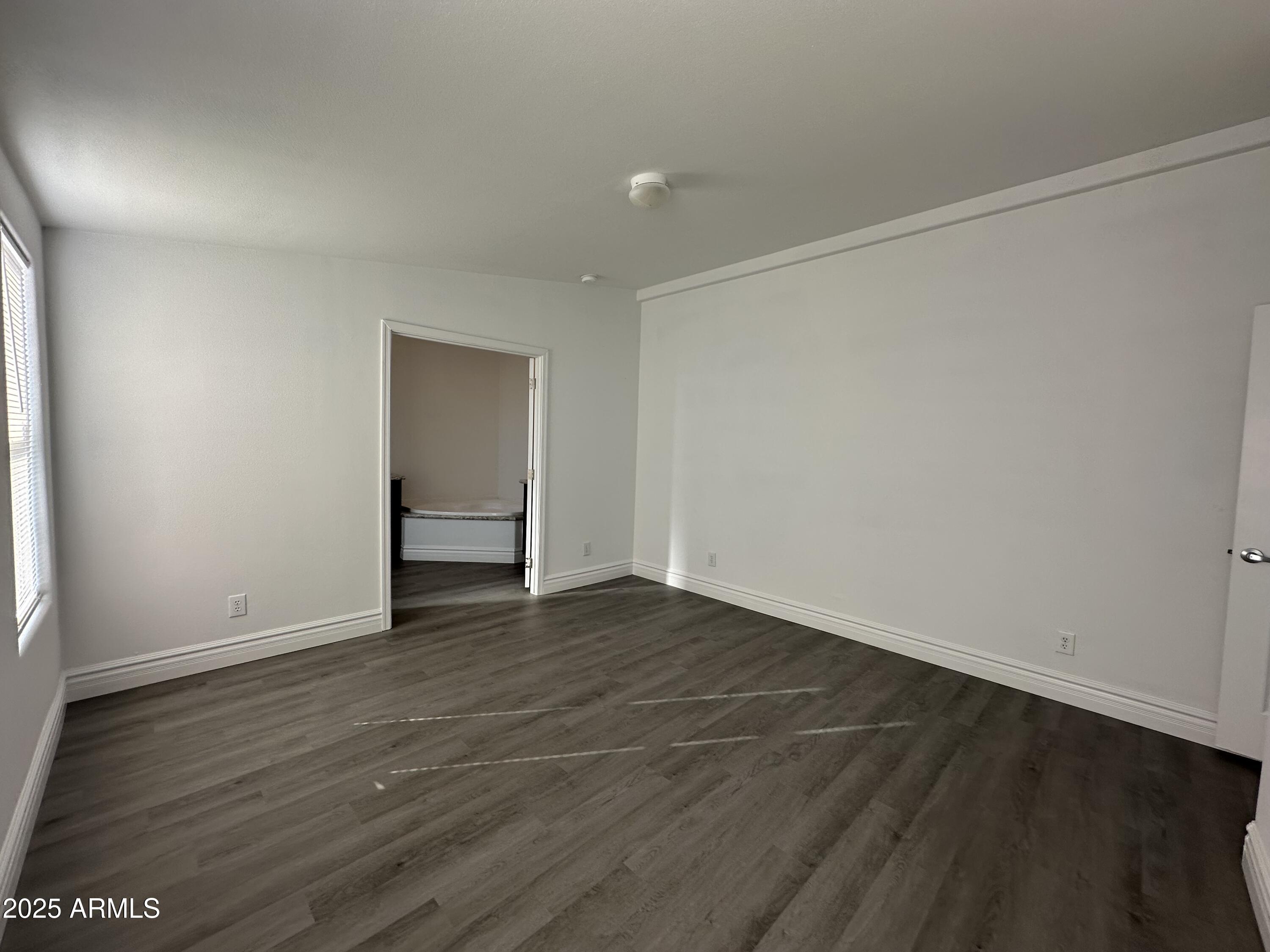 38007 West McDowell Road Tonopah, AZ 85354 - Photo 9 of 44 a view of an empty room with wooden floor and a window