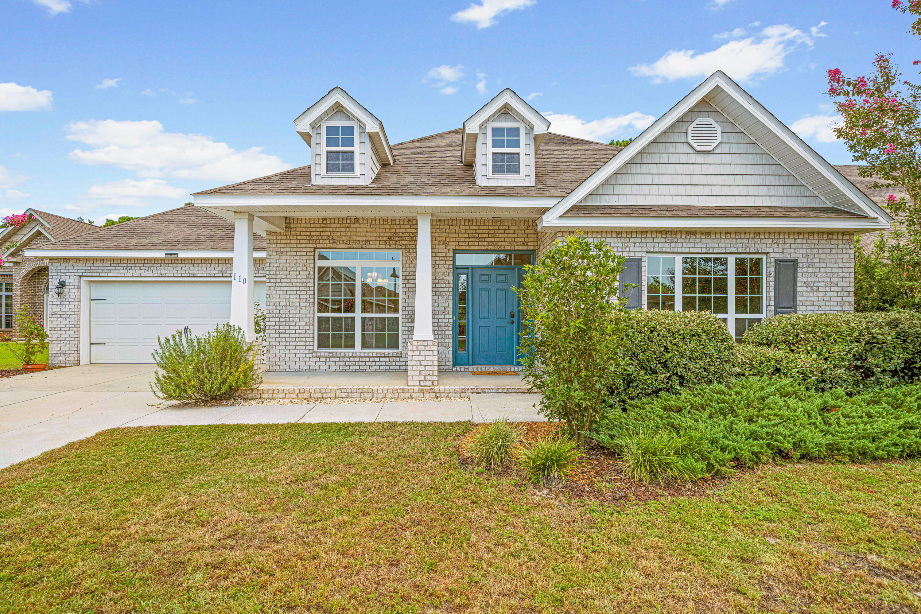 a front view of a house with a garden and yard