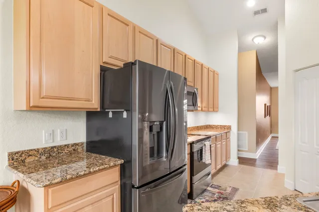 a kitchen with stainless steel appliances granite countertop a refrigerator and a sink