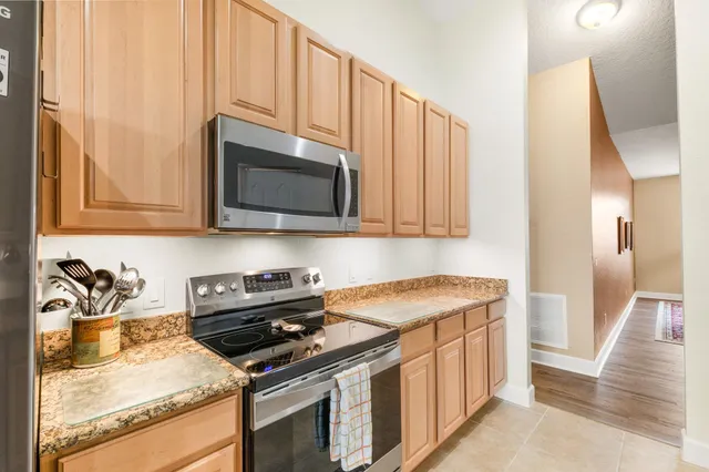 a kitchen with stainless steel appliances granite countertop a sink a stove a microwave oven and cabinets