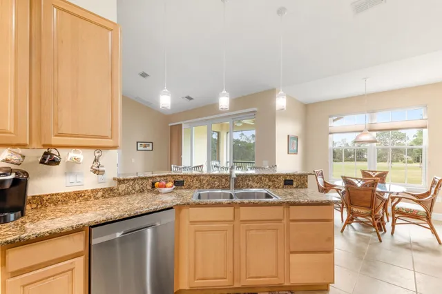 a kitchen with granite countertop a sink and white cabinets
