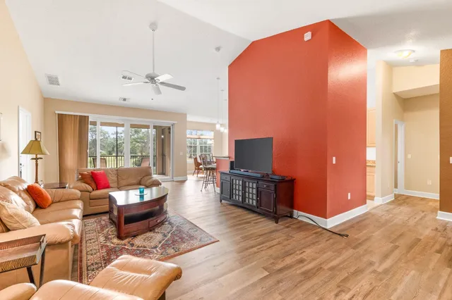 a living room with furniture a dining table and a flat screen tv