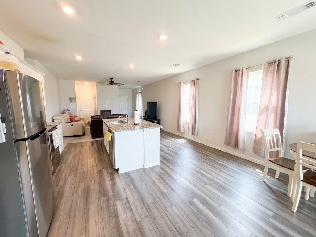 Wood-look flooring and recessed lighting define this open-concept main-level living space.