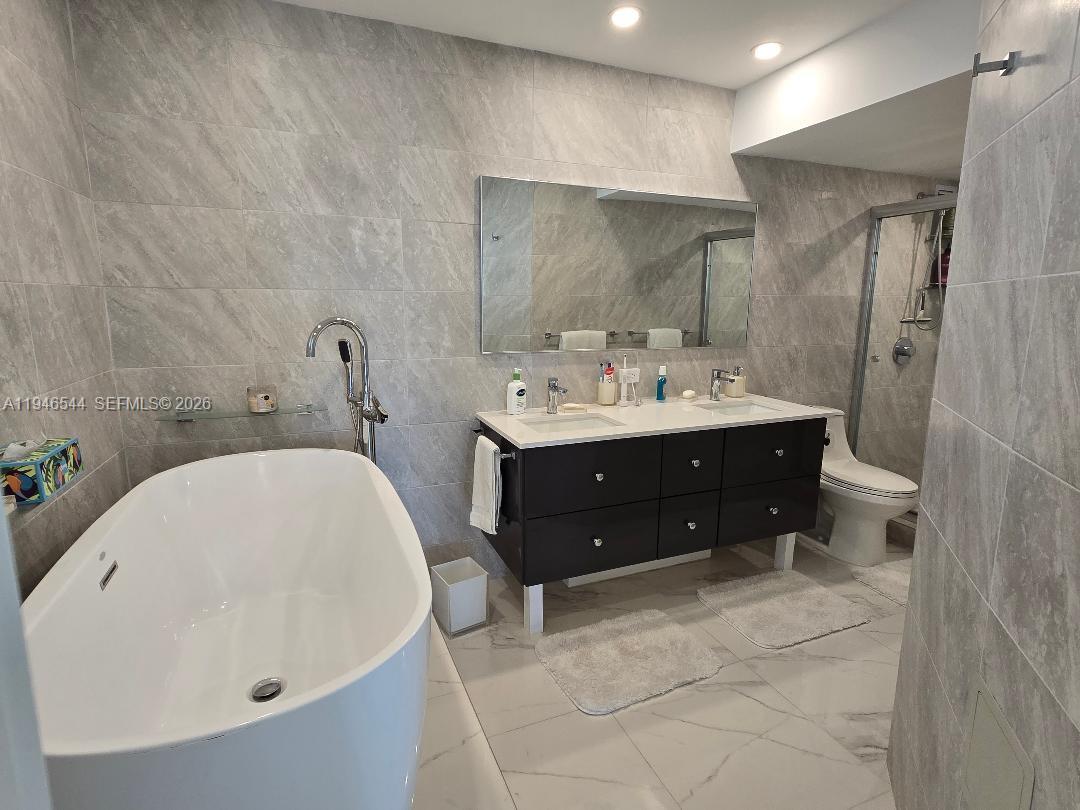 9225 Collins Avenue, Unit 1102 Surfside, FL 33154 - Photo 13 of 15 a en suite bathroom with a sink and a mirror