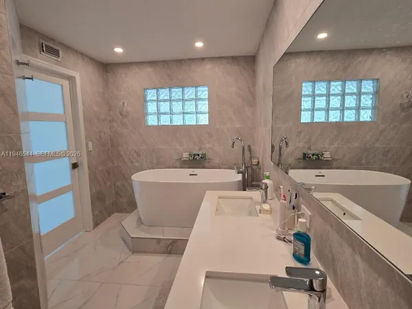 a view of a bathroom with a tub sink and mirror
