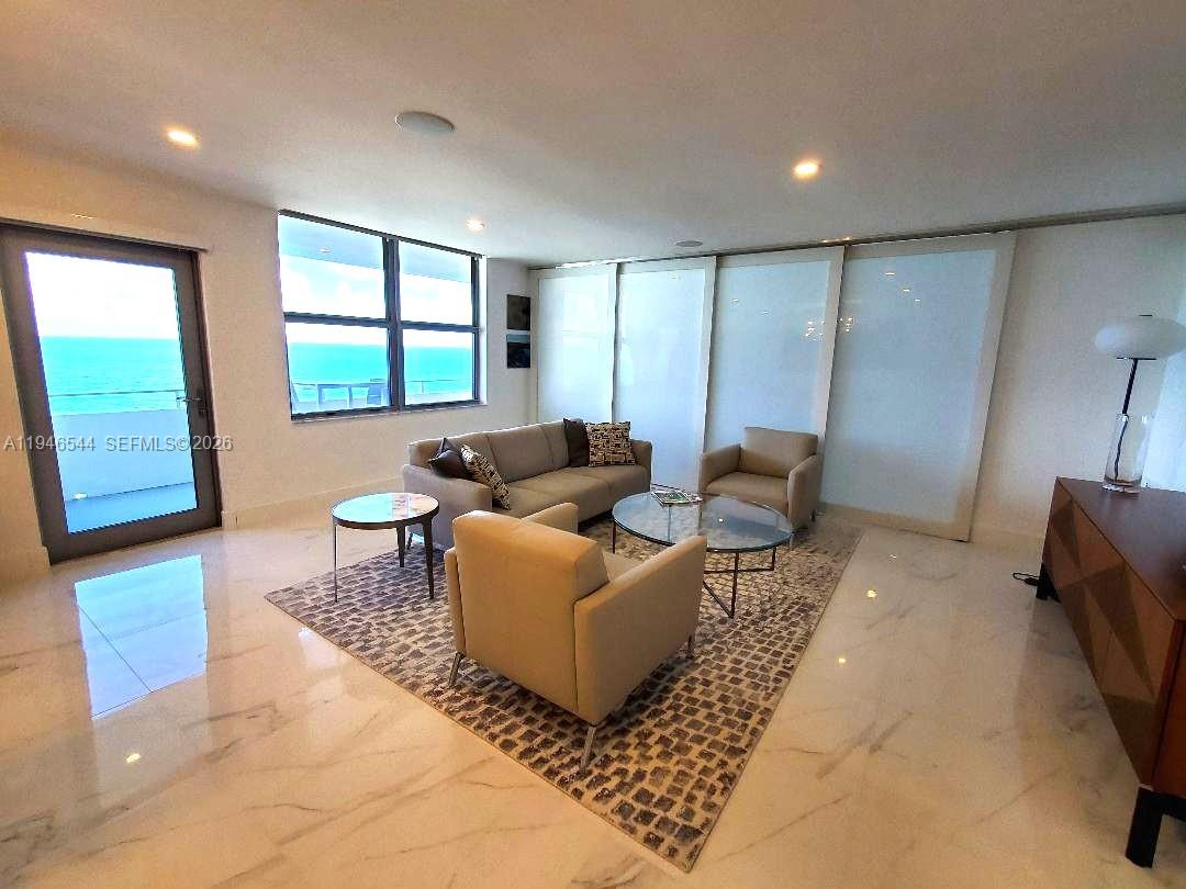 9225 Collins Avenue, Unit 1102 Surfside, FL 33154 - Photo 2 of 15 a living room with furniture and a window