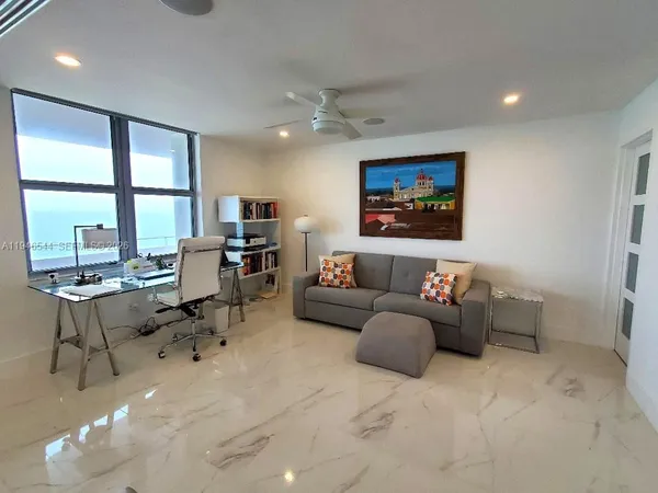 a living room with furniture a large window and a flat screen tv