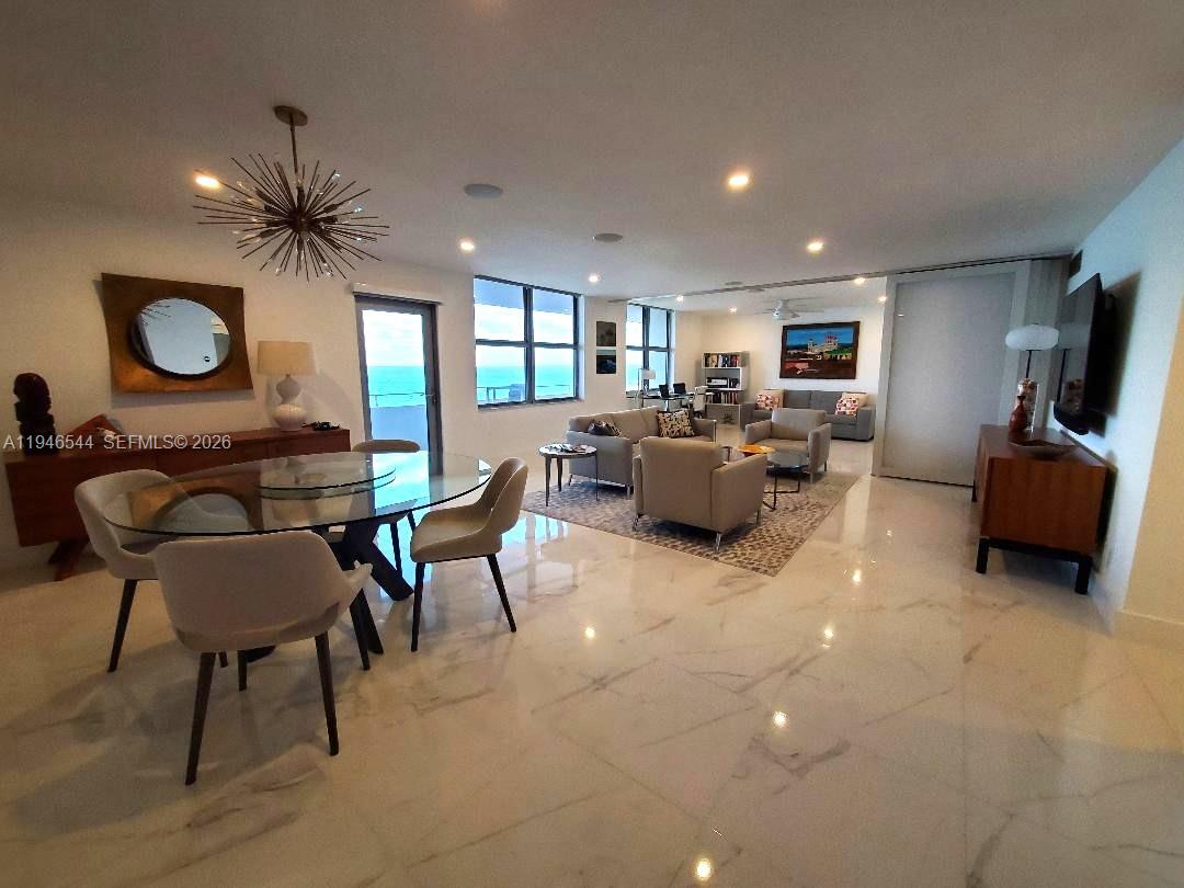 9225 Collins Avenue, Unit 1102 Surfside, FL 33154 - Photo 6 of 15 a living room with furniture and a flat screen tv