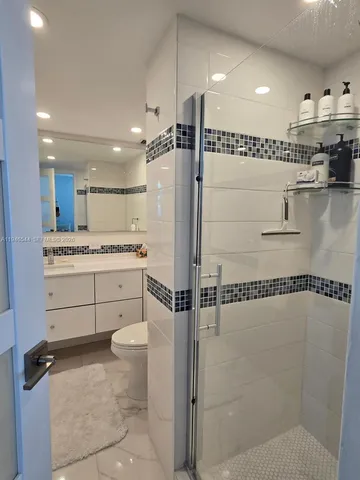 a bathroom with a shower a sink and a toilet