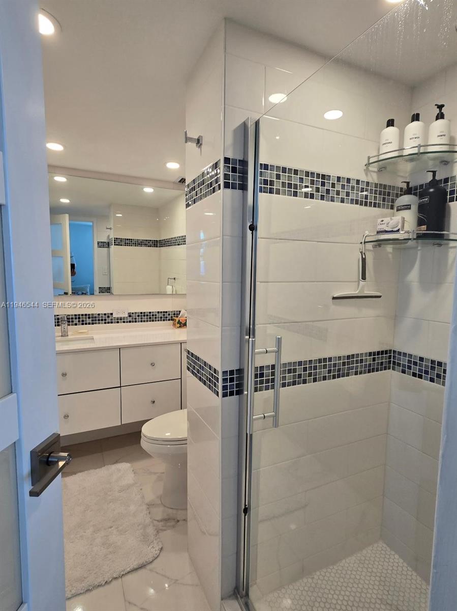 9225 Collins Avenue, Unit 1102 Surfside, FL 33154 - Photo 8 of 15 a bathroom with a shower a sink and a toilet