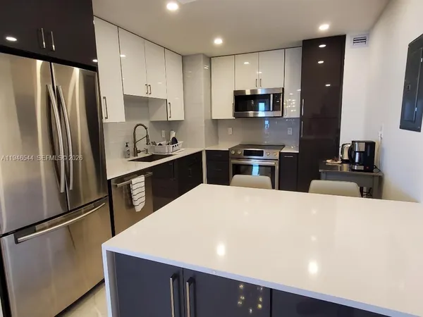 a kitchen with stainless steel appliances a refrigerator sink and stove